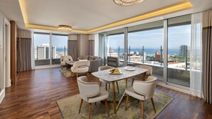A modern living room with a dining area, large windows with a city view, and a chandelier. - Titanic Port Bakirkoy (Istanbul)