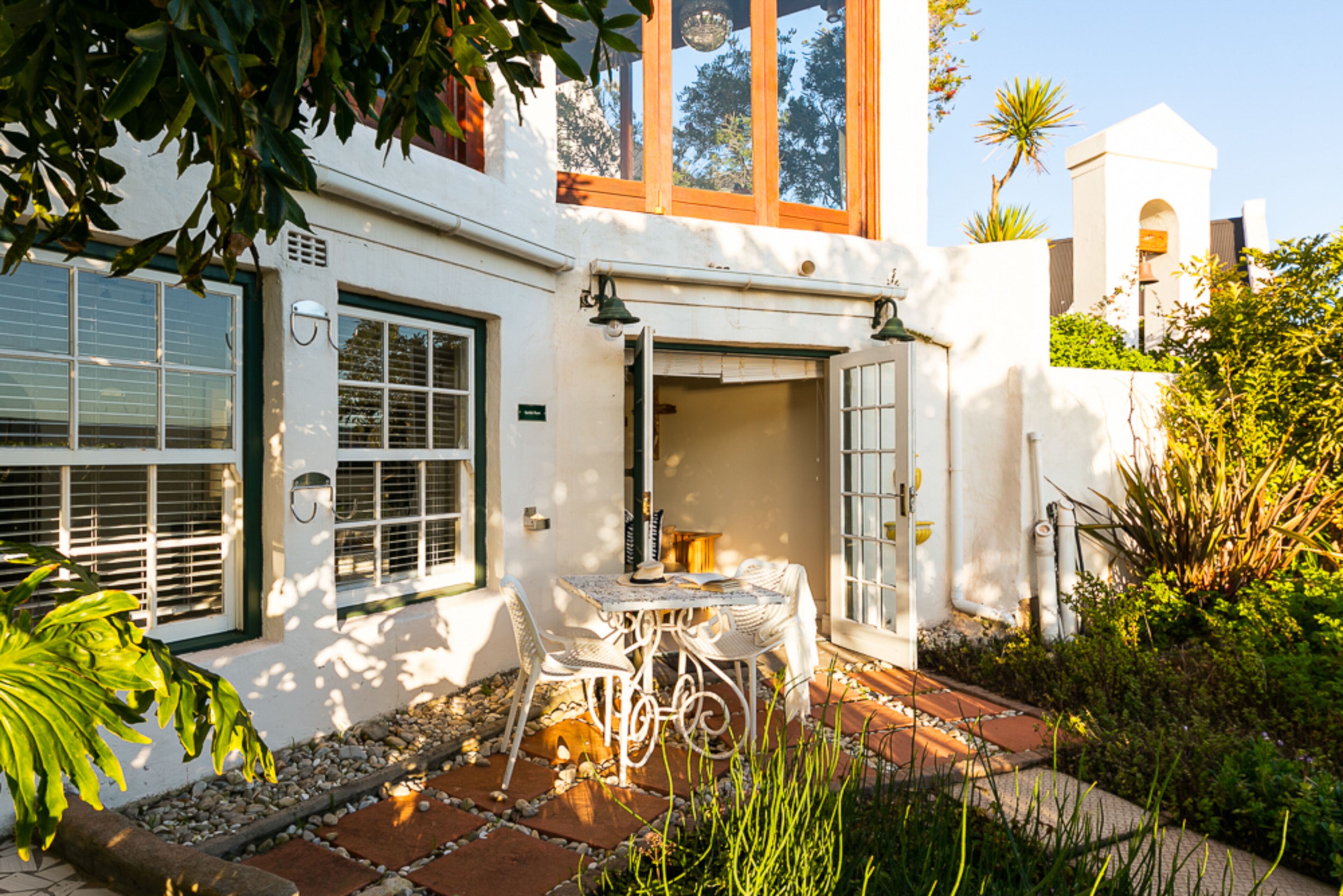 A white building with a patio area featuring a table and chairs.