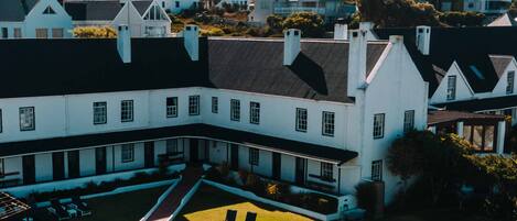 A large building with a swimming pool and lounge chairs.