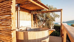 A wooden hot tub with a wooden deck, a wooden pergola, and a view of the sea. - The Farmhouse Hotel (Langebaan)