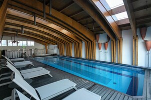 Una piscina techada, sillones reclinables de piscina