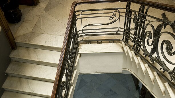A grand staircase with ornate metal railings and a polished marble floor. - Pinto Storey Hotel (Naples)