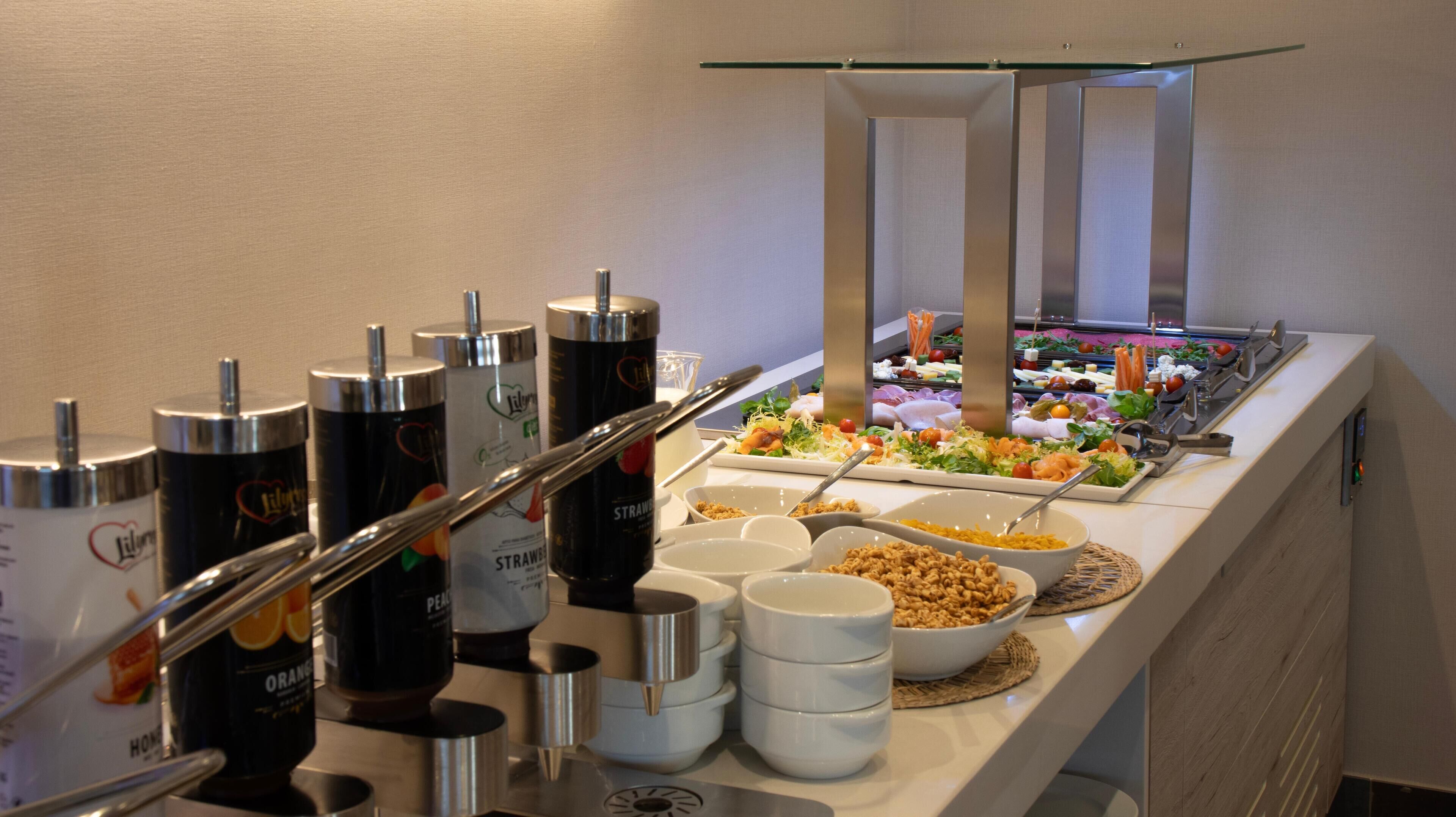 A buffet setup with various food items and beverage dispensers.
