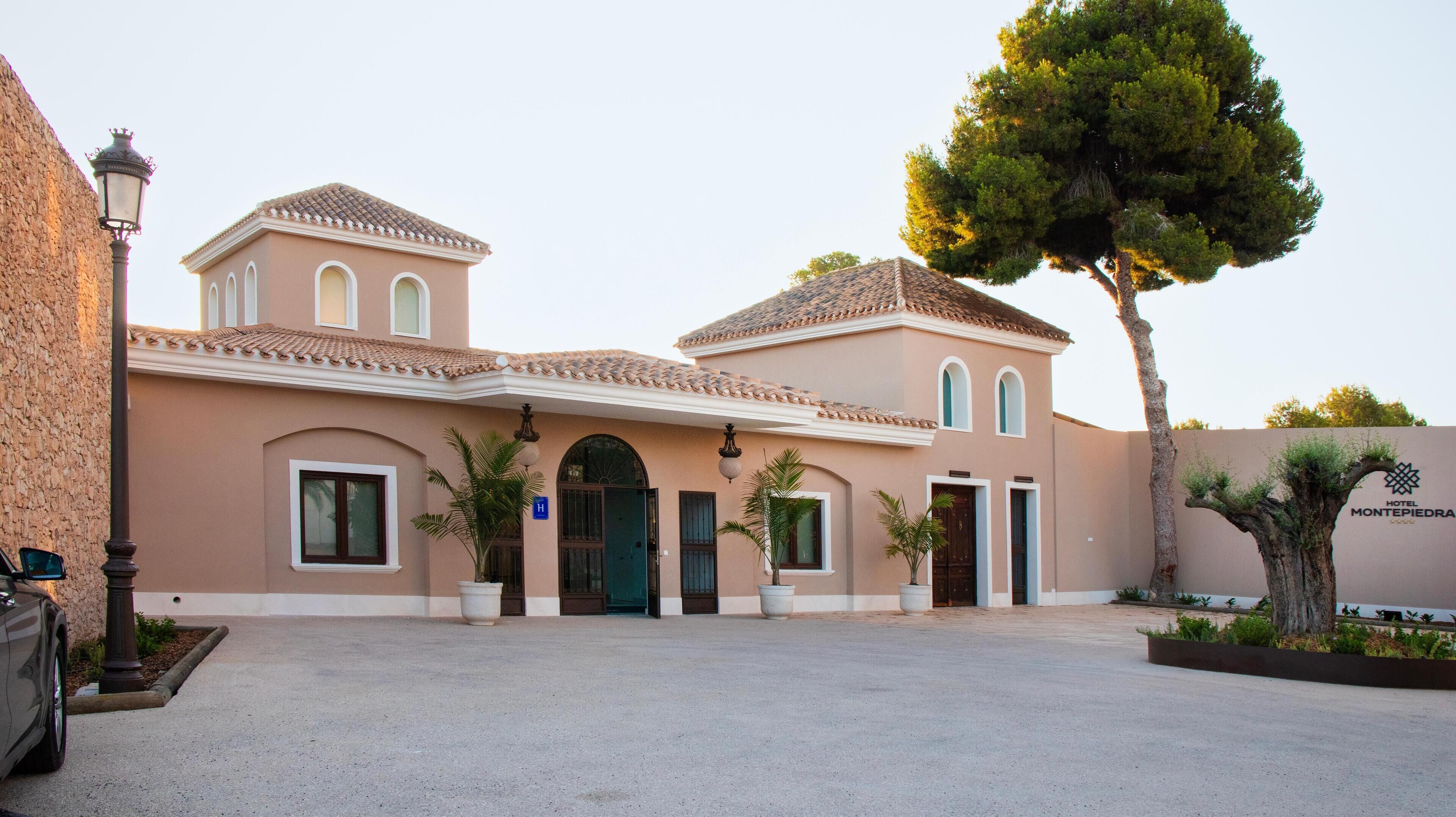 A two-story hotel with a symmetrical facade, featuring a central entrance flanked by two wings.