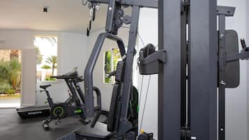 A gym with exercise equipment, a treadmill, and a stationary bike.