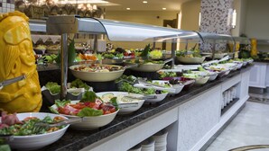 Un bufé con diversas opciones de comida, como ensaladas, frutas y carnes.