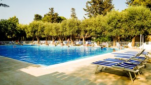 A swimming pool with lounge chairs and a white fence. - Hotel Baia del Sole (Ragusa)
