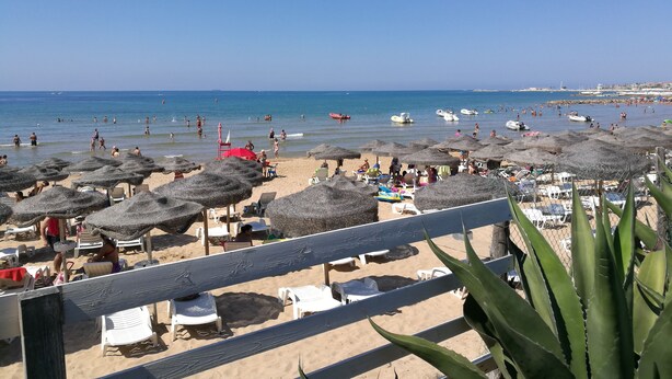 A beach with numerous umbrellas and sun loungers, a sandy shore, and the sea in the background. - Hotel Baia del Sole (Ragusa)