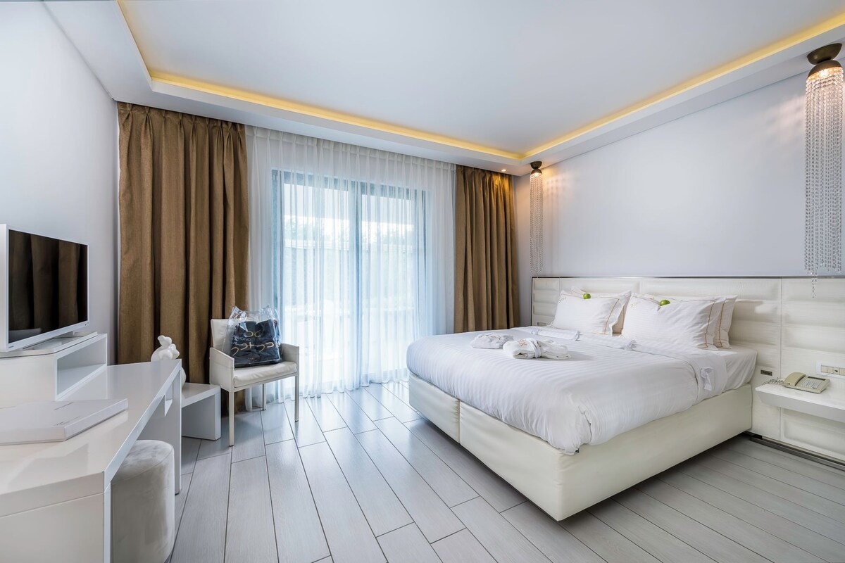 Une chambre d’hôtel moderne équipée d’un grand lit, d’un bureau, d’une chaise et d’un téléviseur.