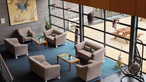 Un'area lounge moderna con divani, un tavolino da caffè e piante sospese.