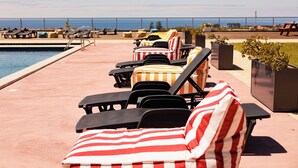 Area piscina con lettini e vista sull'oceano.