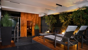 Un espace de détente moderne avec des meubles en osier, un mur d’accent en bois et des plantes d’intérieur.