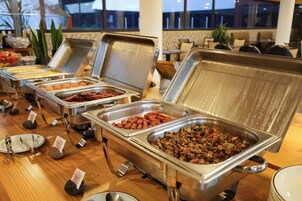 A buffet with multiple food stations, including a variety of meats and vegetables.