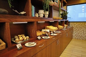 A buffet setup with various food items and utensils. - Antillia Hotel (Ponta Delgada)
