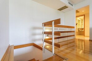 A room with a wooden bench, white walls, and a wooden floor. - Antillia Hotel (Ponta Delgada)