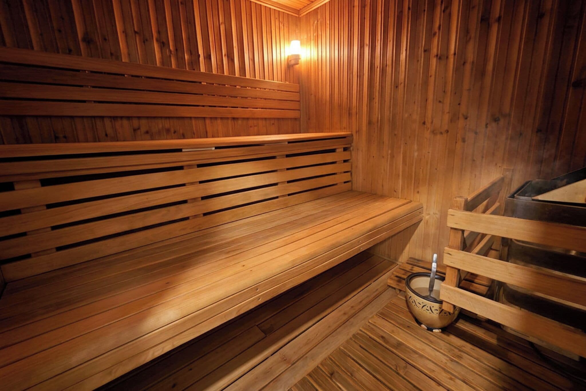 Banco de madera en una sauna con otro banco y una bañera de sauna.