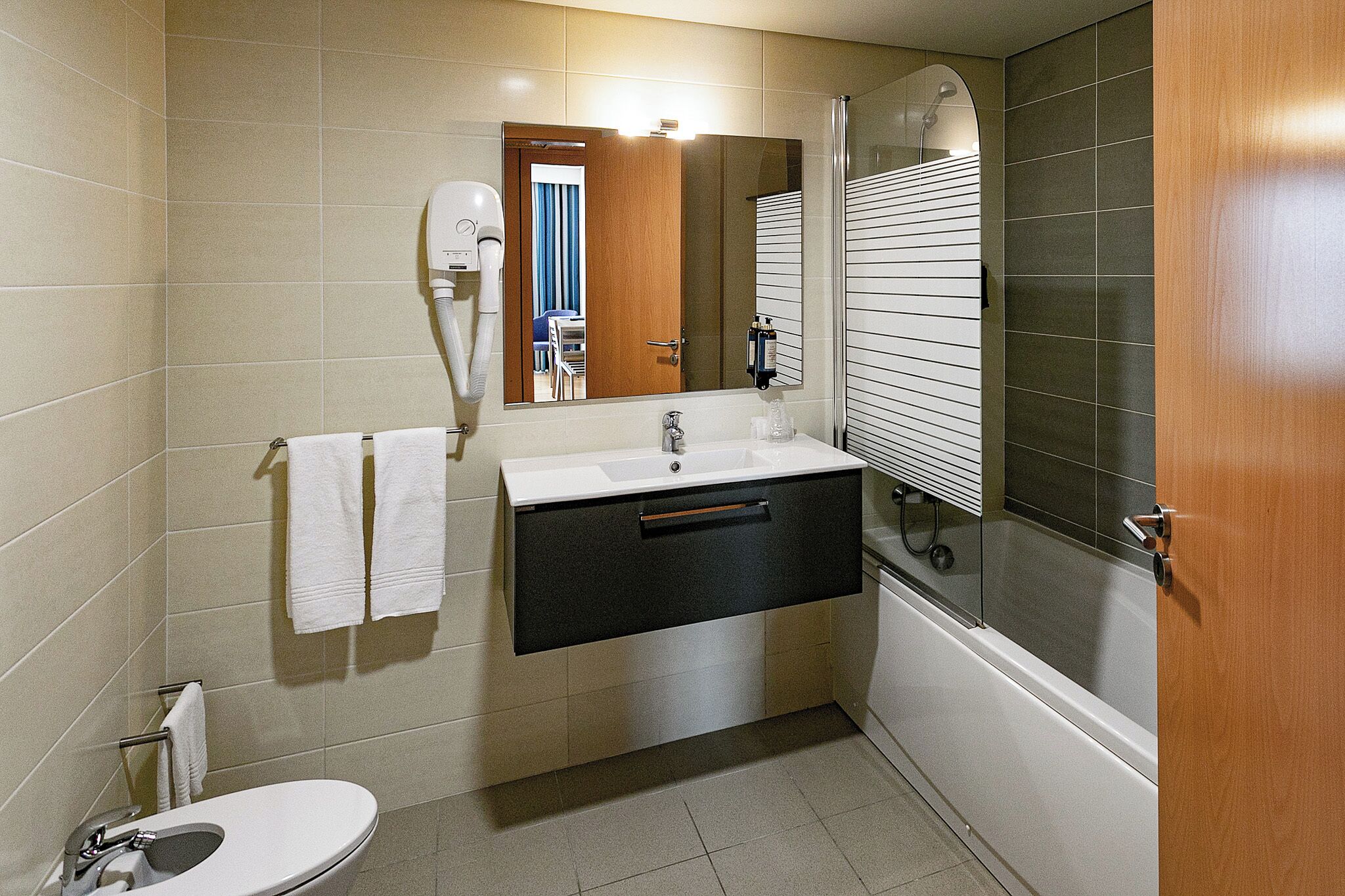 Un baño pequeño con inodoro, lavabo y ducha.