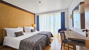 A hotel room with two beds, a desk, and a chair. - Antillia Hotel (Ponta Delgada)