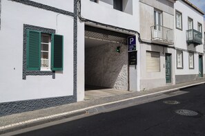 A building with a parking sign, a green shuttered window, and a visible entrance. - Antillia Hotel (Ponta Delgada)