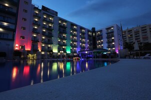 Een hotel met meerdere verdiepingen, balkons en een zwembad.