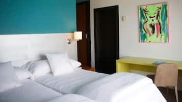 Ein Hotelzimmer mit Bett, Schreibtisch und Stuhl.