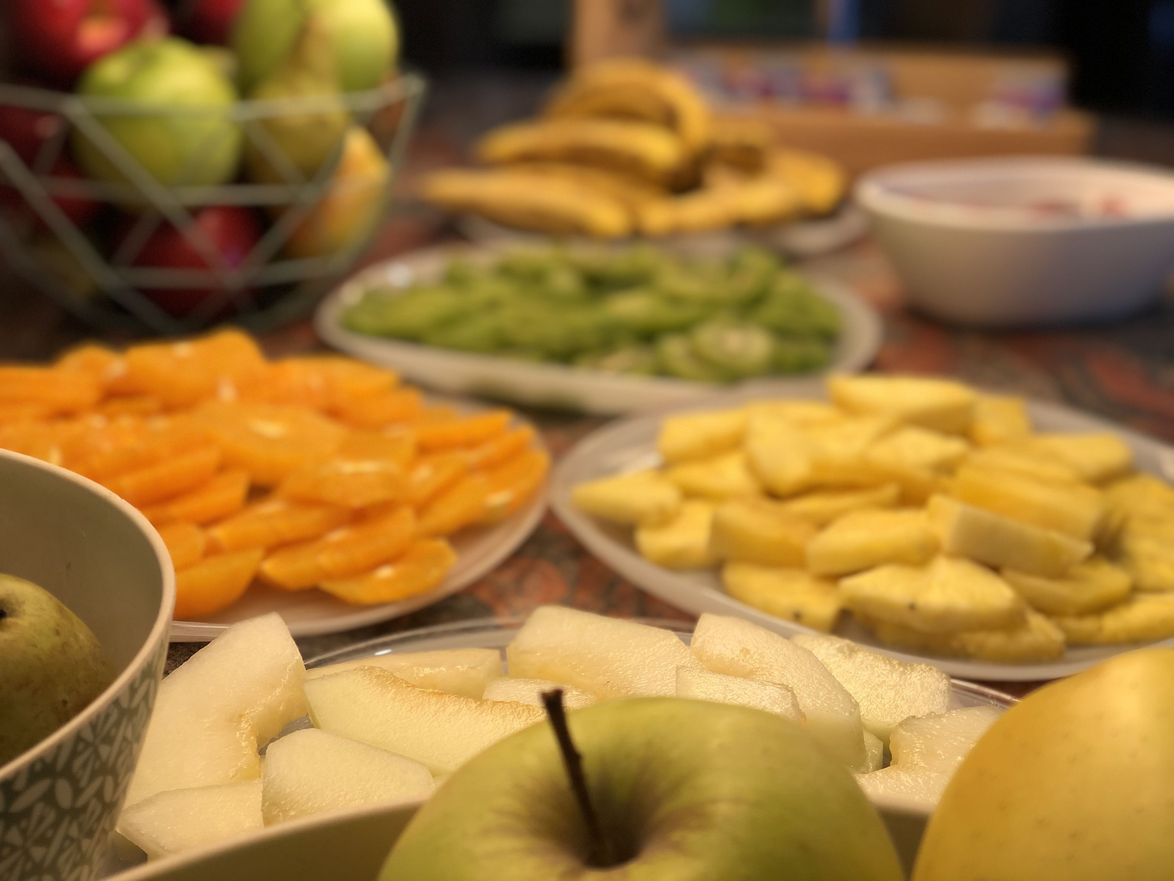 A table with various fruits and vegetables, including apples, oranges, and bananas.