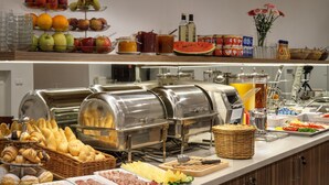 A buffet with various food items, including bread, pastries, meats, and fruits. - Hotel Taurus (Prague)