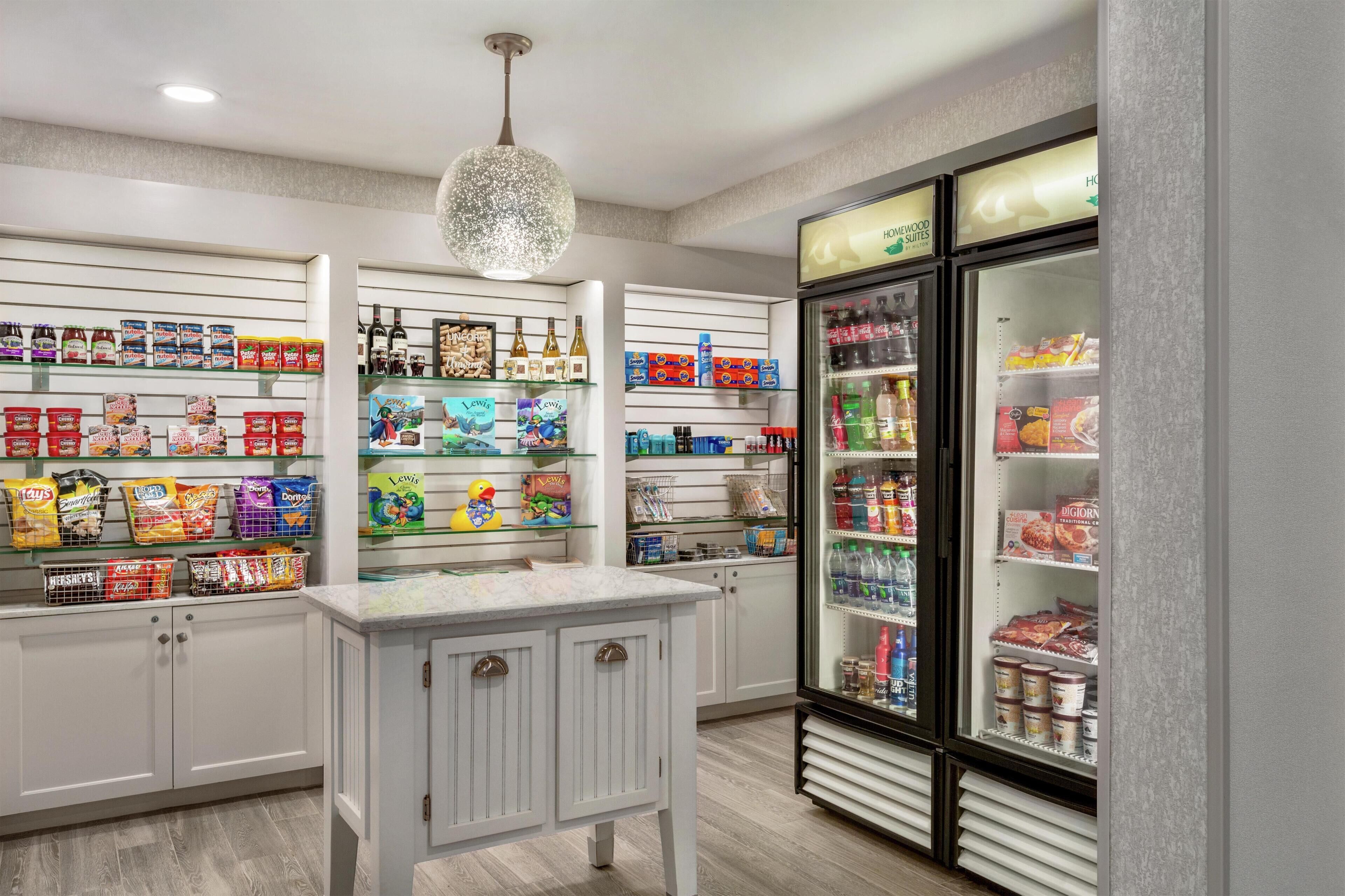 A well-lit store with shelves stocked with snacks, beverages, and household items.