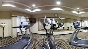A hotel fitness room with treadmills, a mirror, and a clock on the wall. - Holiday Inn Express Hotel & Suites Crestview by IHG (Crestview)