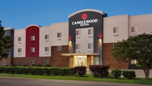 Een hotel met een opvallende rode en witte gevel, een ruime entree en een verzorgd gazon.