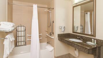 A bathroom with a bathtub, a shower, a sink, and a mirror.