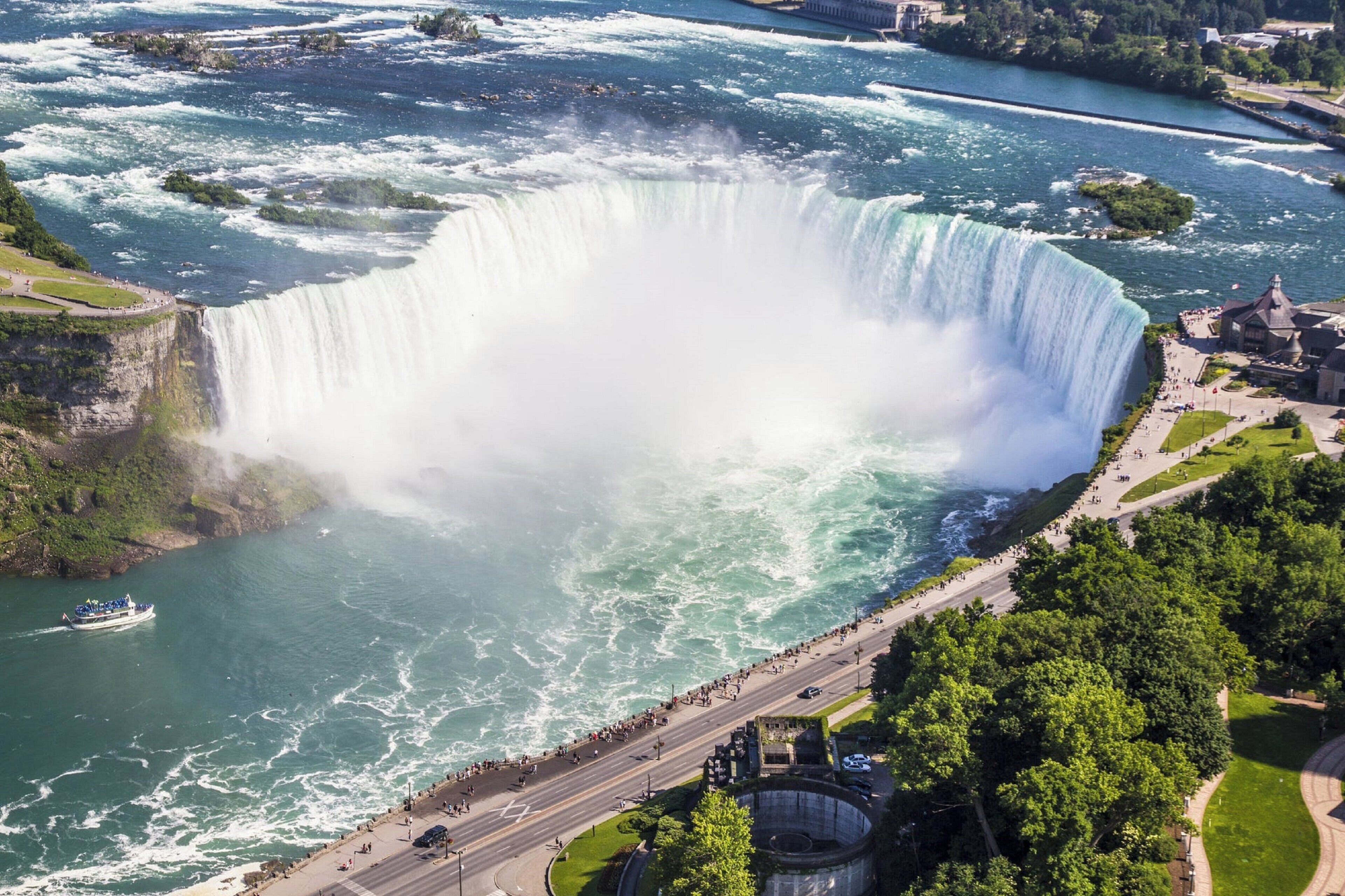 Une grande cascade avec un espace d’observation et une route qui passe à proximité.