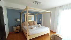 A four-poster bed with a wooden frame, two bedside tables with lamps, a mirror above the bed, and a chair in the corner. - Hotel ITC Salamanca by Soho Boutique (Salamanca)
