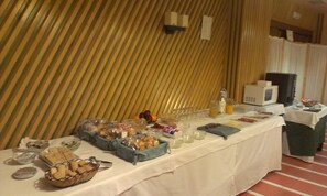 Ein Buffet mit verschiedenen Speisen und Getränken vor einer gestreiften Wand.
