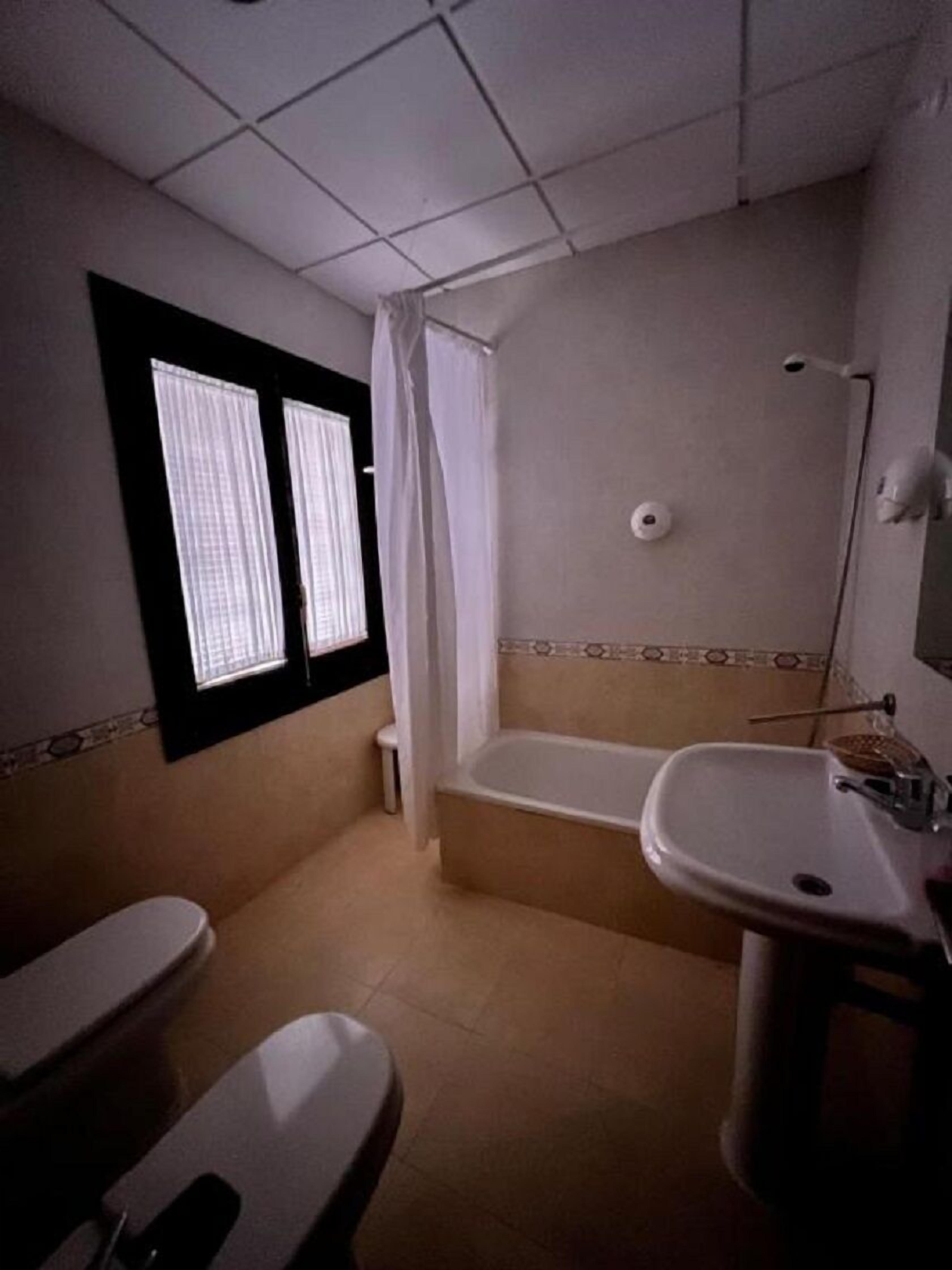 A bathroom with a toilet, bathtub, and sink.