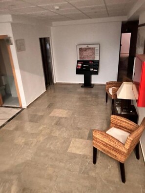 A lobby with a reception desk, a map display, and wicker chairs. - Las Tablas (Daimiel)