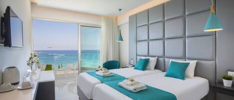 A modern hotel room with a large bed, a desk with a coffee maker, and a view of the ocean.