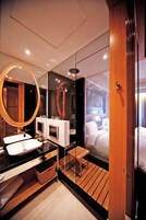 Een moderne badkamer met een grote spiegel, twee wastafels en een houten vloer.