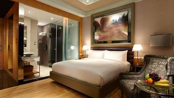 Een moderne hotelkamer met een groot bed, een zithoek met een tafel, en een badkamer die door een open deur zichtbaar is.