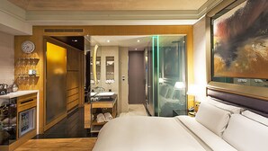 Una habitación de hotel con cama, baño y minibar.