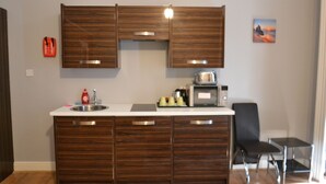 A kitchen with wooden cabinets, a microwave, and a sink.