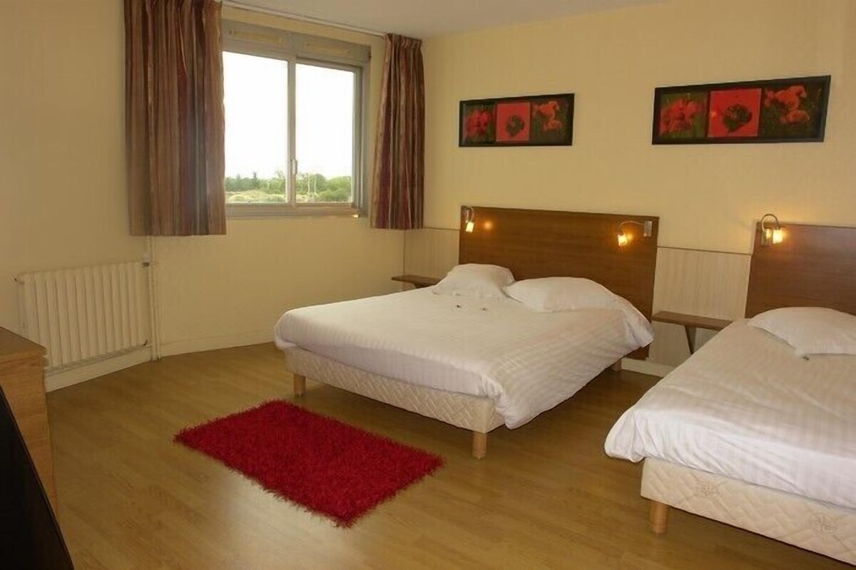 Habitación de hotel con dos camas, un tapete rojo y obras de arte en las paredes.
