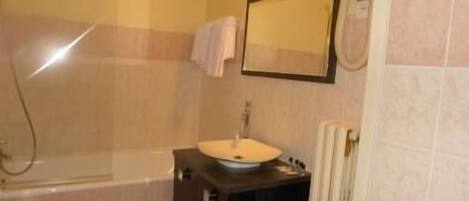 Un baño con bañera, lavamanos y espejo.