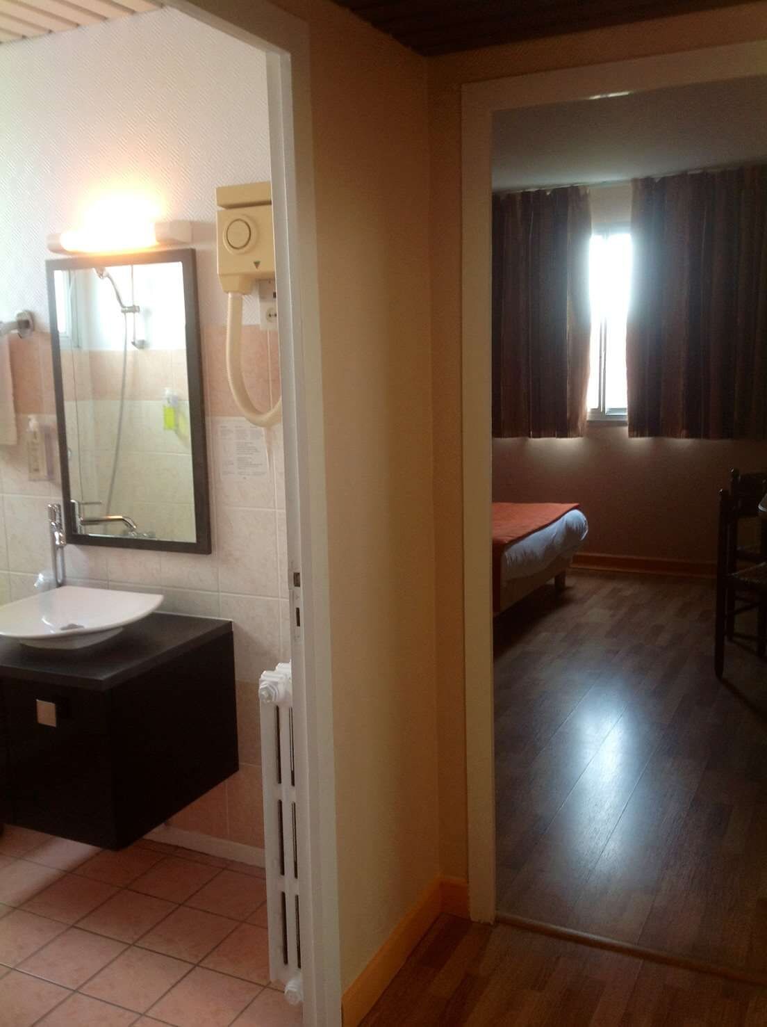 A bathroom with a sink, mirror, and shower.