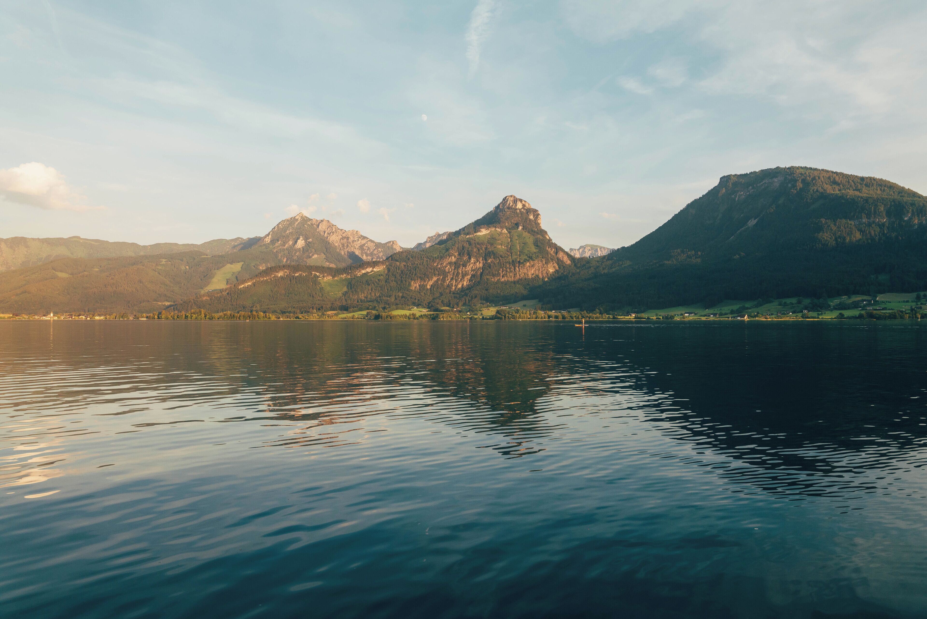 A calm lake with mountains in the background.