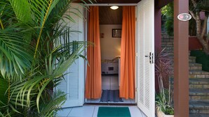 A doorway with a sliding door, a green mat, and a number sign indicating room 7. - Meu Sonho Pousada (Búzios)