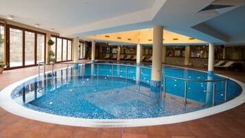 Una piscina cubierta, una piscina al aire libre, tumbonas