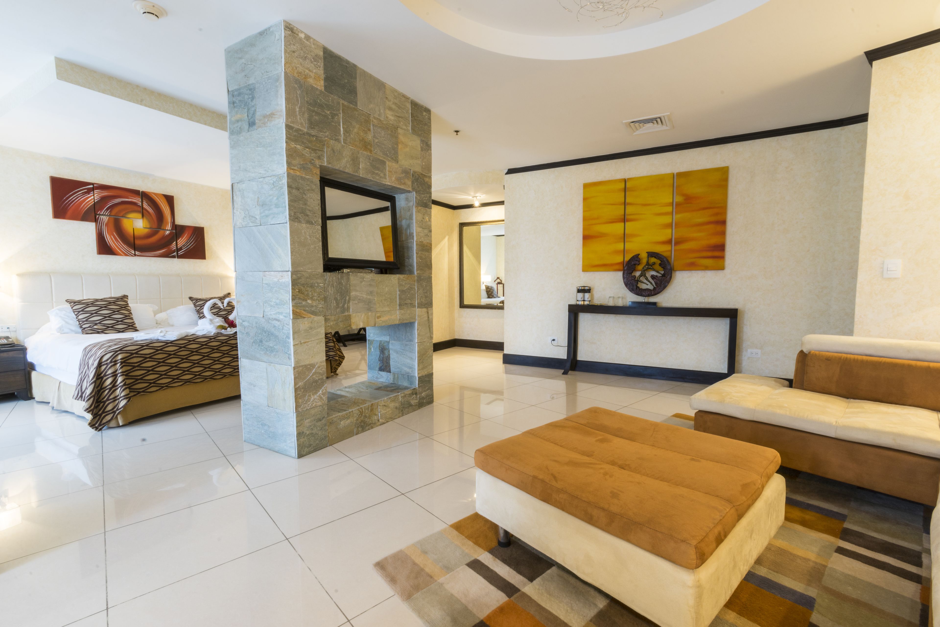 Una sala de estar moderna con chimenea, un sofá y una cama con ropa de cama estampada.