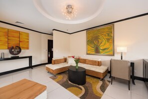 Una sala de estar moderna con un sofá modular, una mesa de centro redonda y un cuadro abstracto grande.