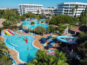 A resort with multiple swimming pools, a water slide, and lounge areas. - Alfagar Aparthotel (Albufeira)